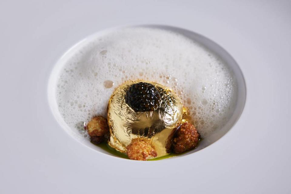 El Huevo de Oro está cubierto de caviar, rodeado de espuma y acentuado con bocados de coliflor. Remuévalo todo junto y sea testigo de su majestuosidad.