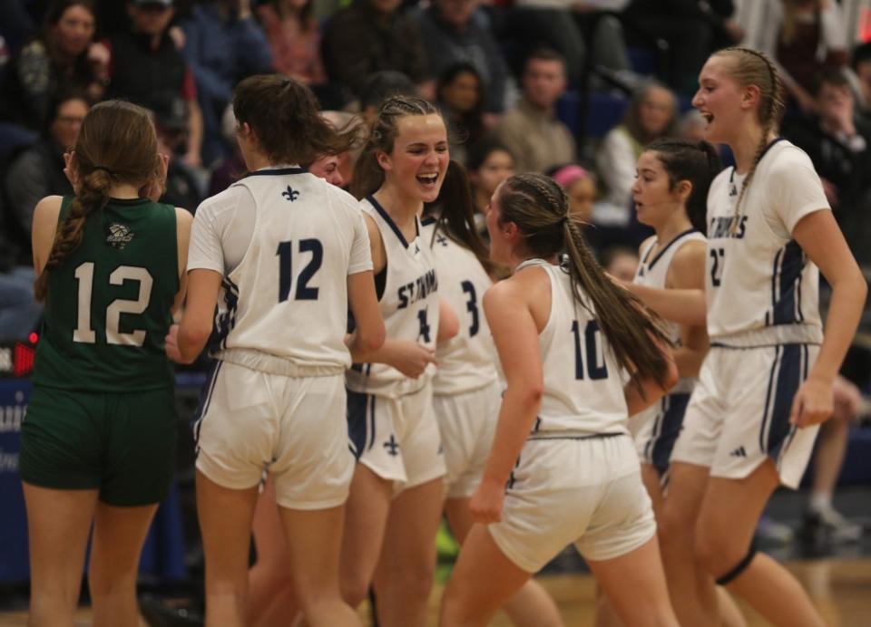 Members of the St. Thomas Aquinas High School girls basketball team celebrate after Thursday's 66-48 win over Hopkinton, and earning the No. 1 seed in the upcoming Division III tournament.