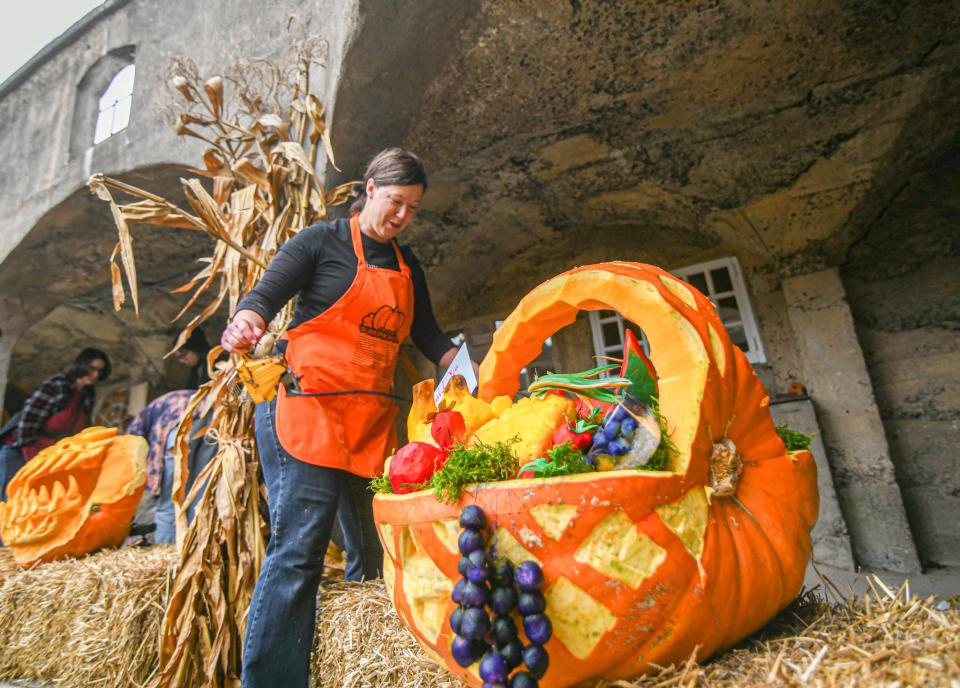 Anne O’Day prepares her carved pumpkin called “Would you like an apple?” for the Pumpkinfest event Saturday beneath the historic arches of the Bucks County Tile Works Oct. 23.