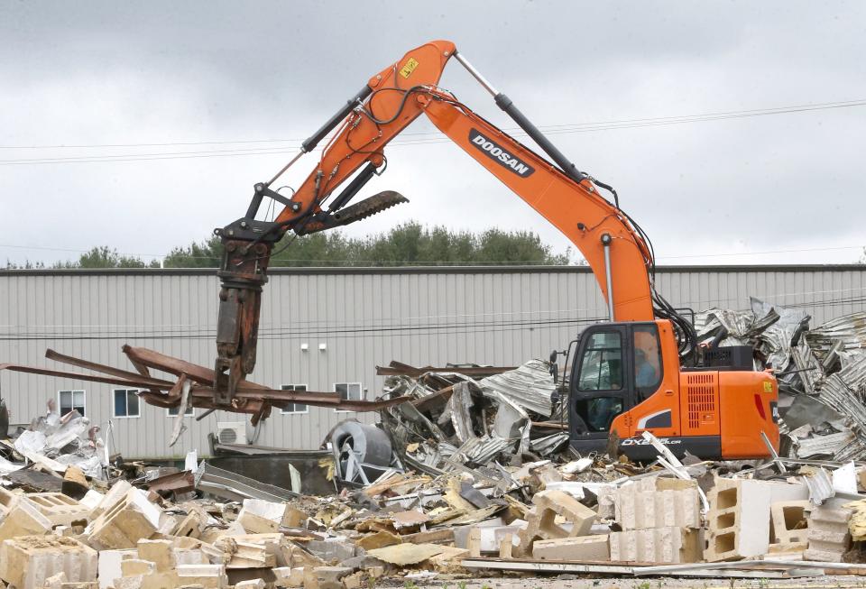 The former Kmart building in North Canton is torn down on Tuesday.