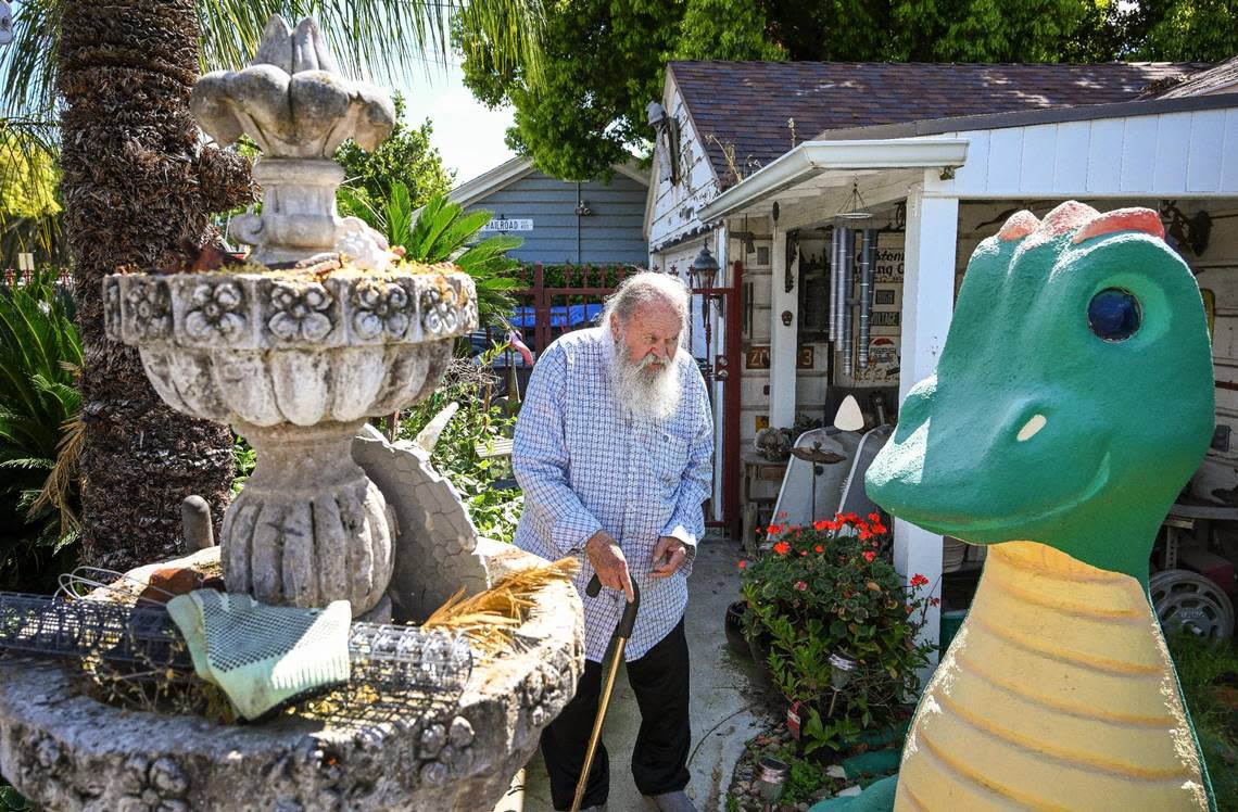 Jim Williams walks through his yard showing off old fountains and dragon sculptures in the Fresno High area where he has created an eye-catching array of art over many decades. CRAIG KOHLRUSS/ckohlruss@fresnobee.com