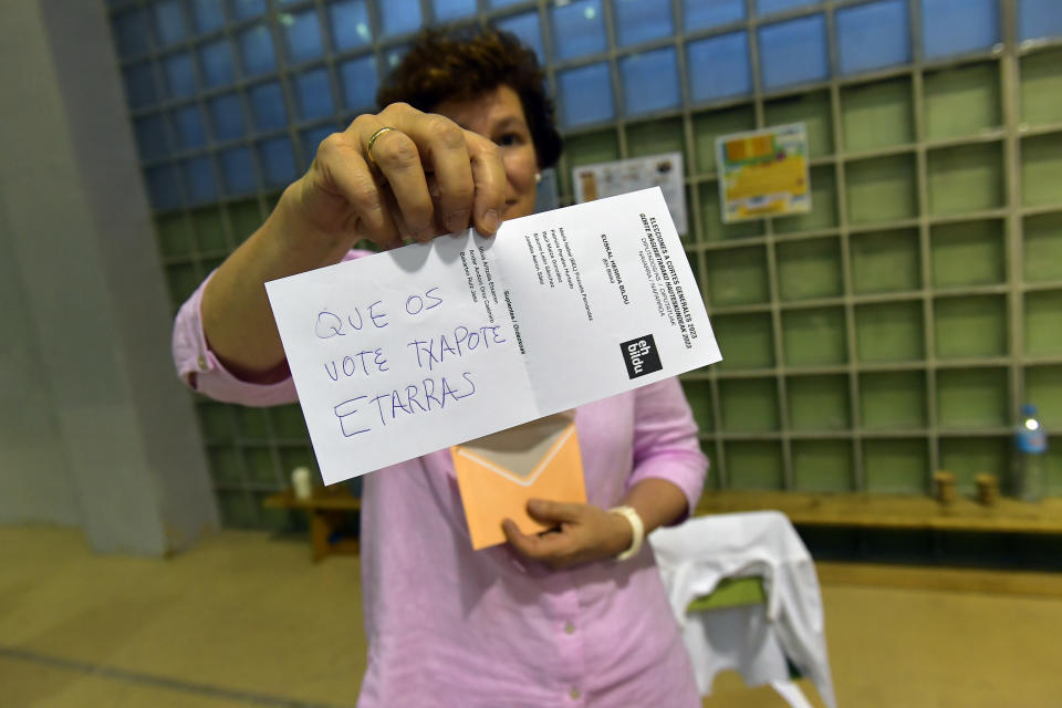 An election official shows an invalid ballot with a handwritten note against the far-left pro-independence Basque party Bildu as ballots are counted at a polling station in Pamplona, northern Spain, Sunday July 23, 2023. Spain is holding general elections, that could make the country the latest European Union member to swing to the political right, at the height of summer, when millions of citizens are likely to be vacationing away from their regular polling places.(AP Photo/Alvaro Barrientos)