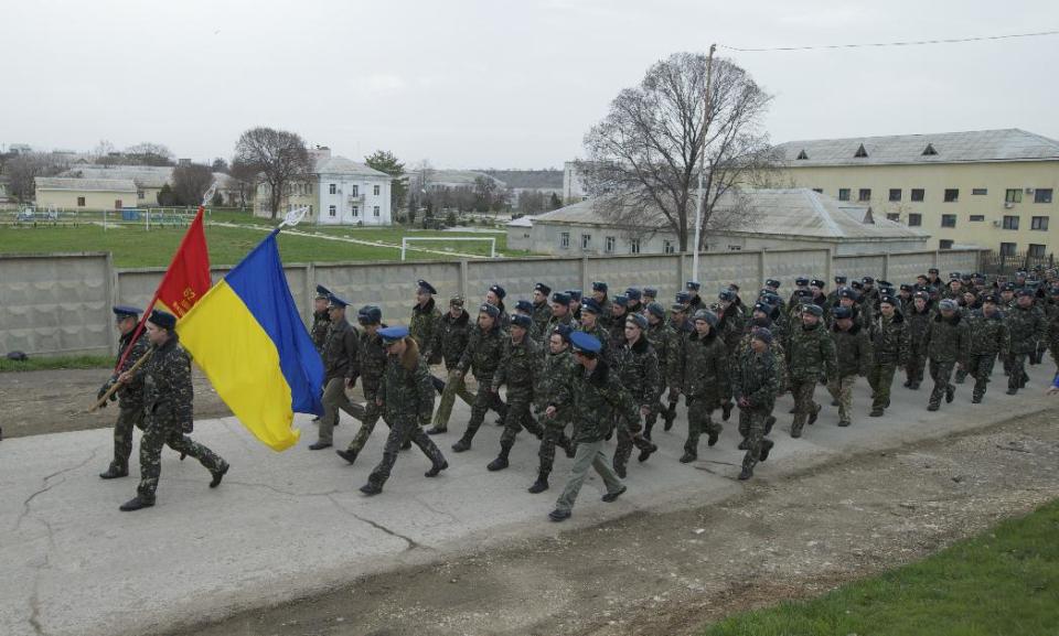 Ukrainian officers march at the Belbek air base, outside Sevastopol, Ukraine, on Tuesday, March 4, 2014. Russian troops, who had taken control over Belbek airbase, fired warning shots in the air as around 300 Ukrainian officers marched towards them to demand their jobs back. (AP Photo/Ivan Sekretarev)