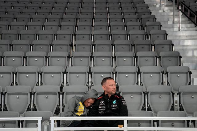 Fans wait around during a delay before the second practice session