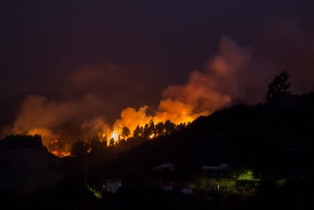 Flames and smoke from a forest fire are seen in the village of Moya in the Canary Island of Gran Canaria