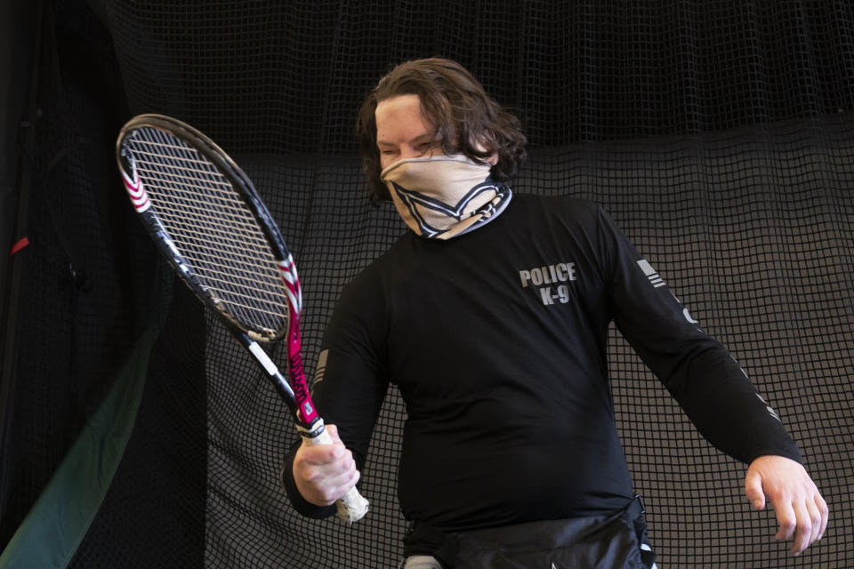 Joe DiMeo holds a tennis racket as he works in a physical therapy session, Jan. 25, 2021 in New York, six months after an extremely rare double hand and face transplant. Since leaving the hospital in November, DiMeo has been in intensive rehabilitation, devoting hours daily to physical, occupational and speech therapy. (AP Photo/Mark Lennihan)