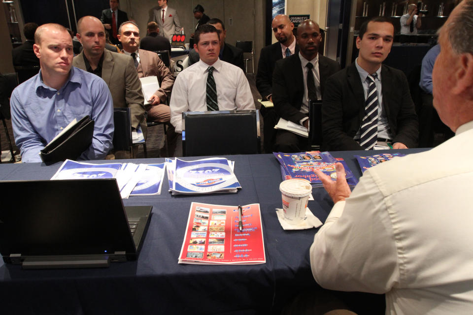 In this Friday Sept. 28, 2012, photo, a group of veterans listen as a representative from White Rose Foods, foreground right, talks about their agency during a job fair introducing veterans to careers in the security and private investigations industry at Yankee Stadium in the Bronx borough of New York. Weekly applications for U.S. unemployment benefits jumped 46,000 in the week ending on Thursday, Oct.18, 2012, to a seasonally adjusted 388,000, the highest in four months. The increase represents a rebound from the previous week's sharp drop. Both swings were largely due to technical factors. (AP Photo/Tina Fineberg)