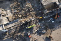 Ukrainian State Emergency Service firefighters work to take away debris at a shopping mall burned after a missile strike in Kremenchuk, Ukraine, Tuesday, June 28, 2022. (AP Photo/Efrem Lukatsky)