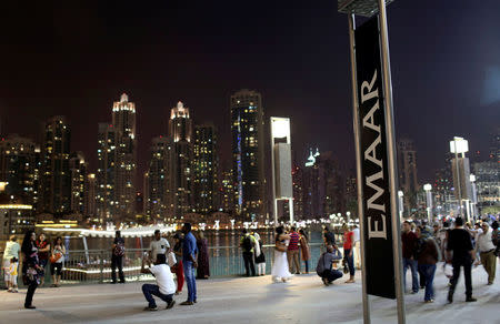 FILE PHOTO: People have their pictures taken near an Emaar sign outside the Dubai Mall, UAE March 15, 2014. REUTERS/Ahmed Jadallah/File Photo