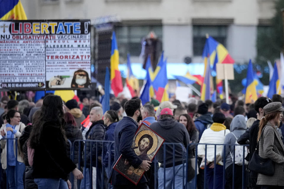 A man holds an icon during an anti-government and anti-vaccination protest organised by the far-right Alliance for the Unity of Romanians or AUR, in Bucharest, Romania, Saturday, Oct. 2, 2021. Thousands took to the streets calling for the government's resignation, as Romania reported 12.590 new COVID-19 infections in the past 24 hour interval, the highest ever daily number since the start of the pandemic. (AP Photo/Vadim Ghirda)