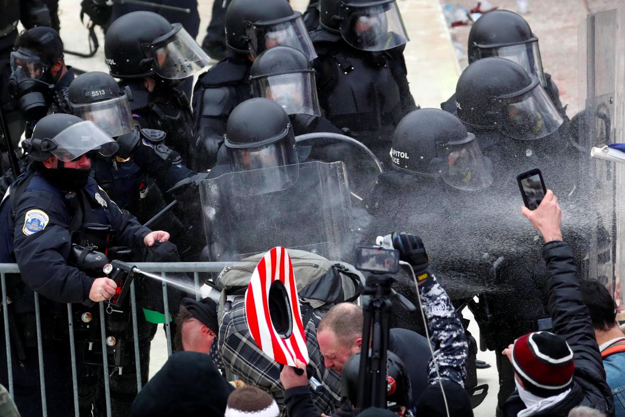 Police officers use pepper spray on pro-Trump protesters during the clashes (REUTERS)
