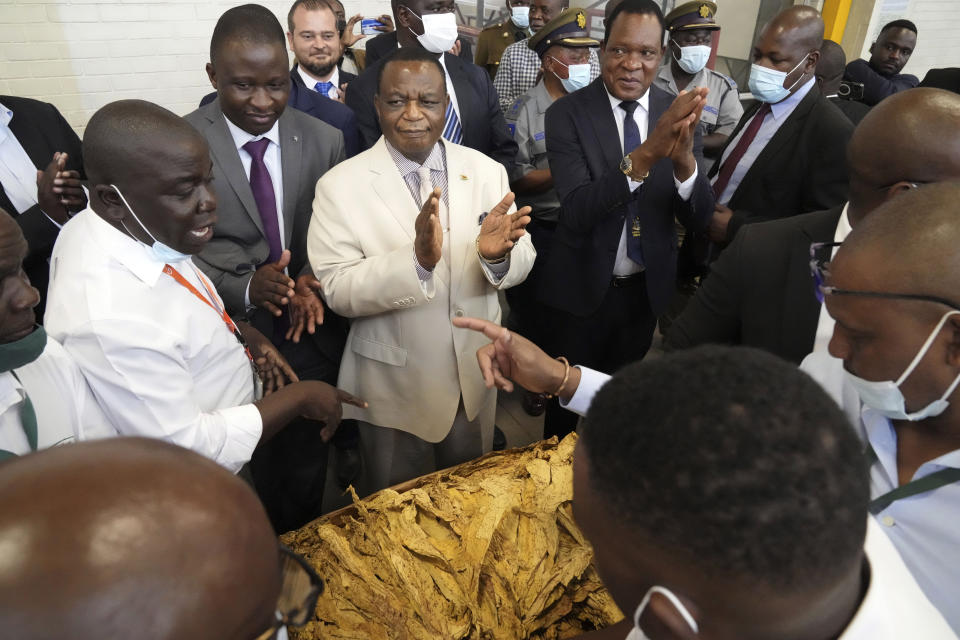 Zimbabwean Deputy President Constantino Chiwenga, centre, attends the official opening of the tobacco marketing season in Harare, Zimbabwe, Wednesday, March, 8, 2023. Zimbabwe's tobacco is expected to increase following good rains as more farmers have planted this crop. Tobacco is one of the biggest export earners in the Southern African country. (AP Photo/Tsvangirayi Mukwazhi)