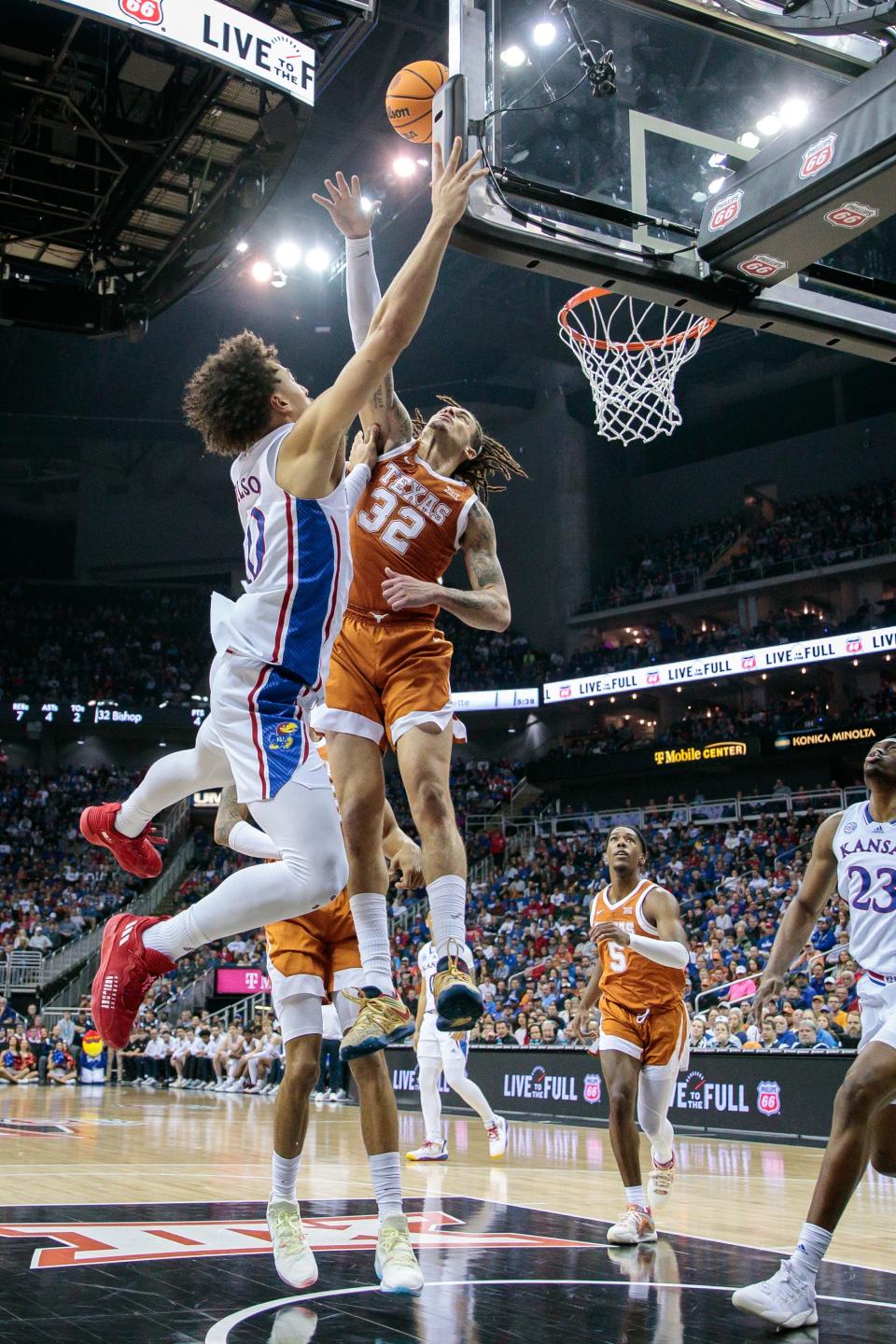 Texas forward Christian Bishop, right, blocks a shot by Kansas  forward Jalen Wilson during the first half of the Big 12 Tournament title game at T-Mobile Center in Kansas City. Bishop and Texas stunned Kansas 76-56 to win the tournament title Saturday.