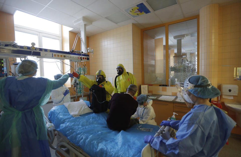 Healthcare workers admit a new COVID-19 patient into an intensive care unit (ICU) at the General University Hospital in Prague, Czech Republic, Tuesday, April 7, 2020. The new coronavirus causes mild or moderate symptoms for most people, but for some, especially older adults and people with existing health problems, it can cause more severe illness or death. (AP Photo/Petr David Josek)