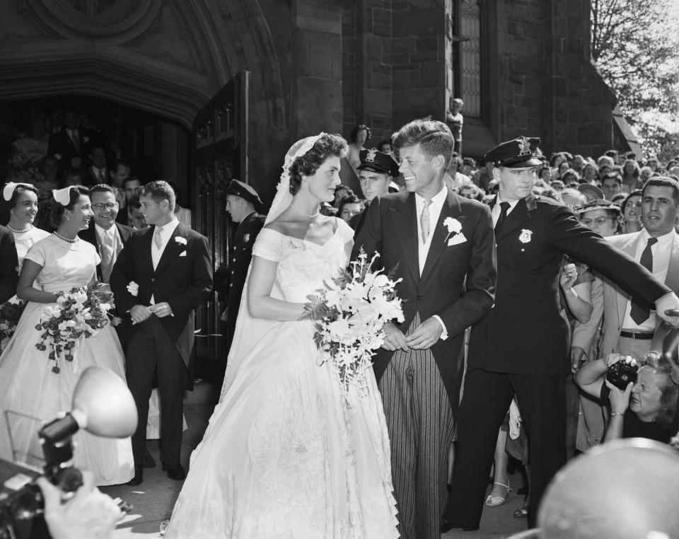 Senator John F. Kennedy and his bride, the former Jacqueline Lee Bouvier, leave a Newport, Rhode Island, church following their wedding ceremony. An estimated one thousand people waited outside the church for the newlyweds.