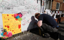 <p>A man signs a message board placed near Grenfell Tower in London, Saturday, June 17, 2017. Police Commander Stuart Cundy said Saturday it will take weeks or longer to recover and identify all the dead in the public housing block that was devastated by a fire early Wednesday. (AP Photo/Kirsty Wigglesworth) </p>