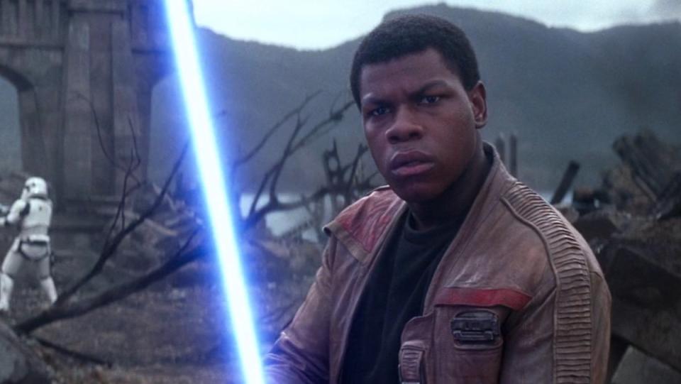 Finn holds a blue lightsaber in The Force Awakens