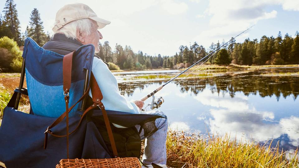 retired man fishing on the shore of a lake