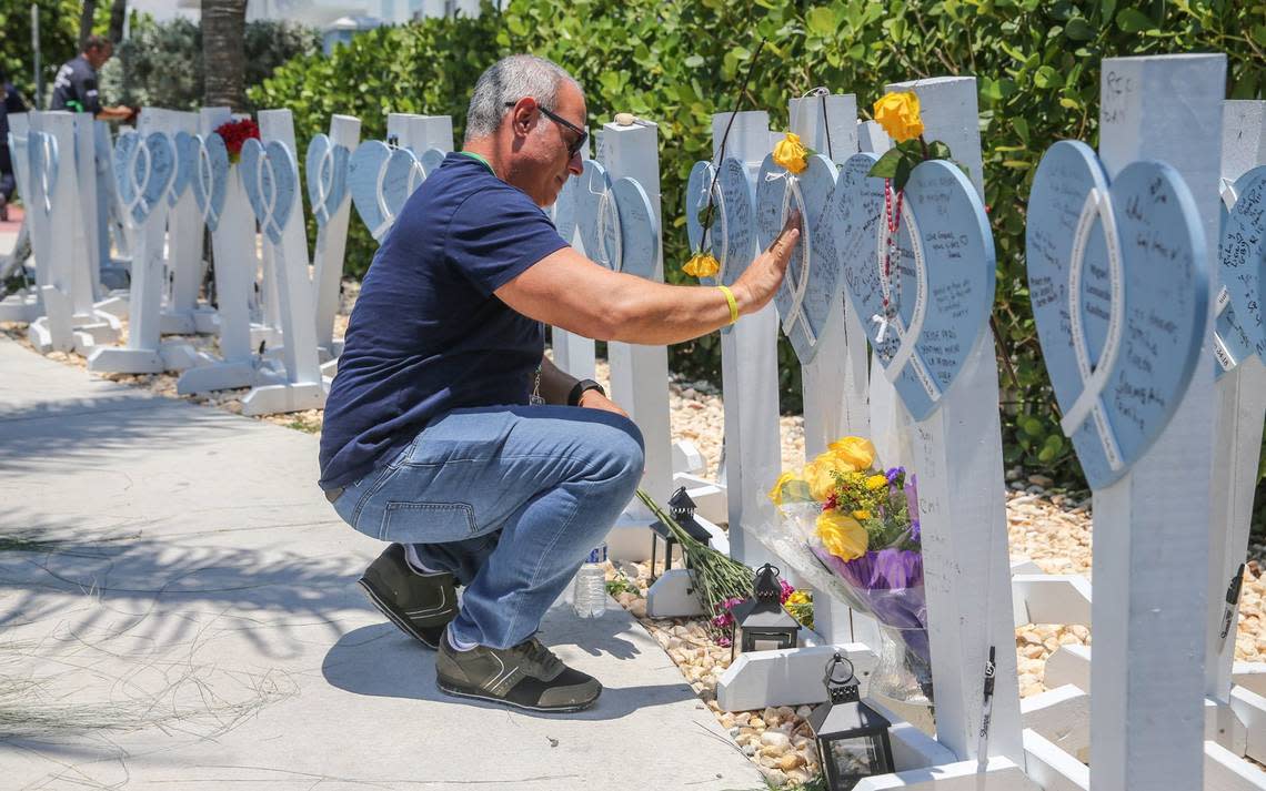 Leonardo Morejon touches the name of his friend Miguel Pazos on a memorial outside an event on June 24, 2022, to mark the one-year anniversary of the collapse of Champlain Towers South in Surfside. Al Diaz/adiaz@miamiherald.com