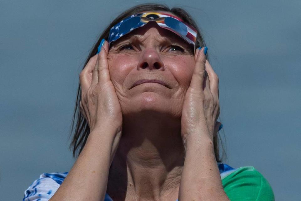 A woman looks on during totality of a solar eclipse from the riverfront in Paducah, Ky., on Monday, April 8, 2024. Ryan C. Hermens/rhermens@herald-leader.com