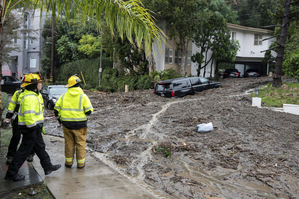 Firefighters look over damage from a large mudslide which occurred at the intersection of Beverly Drive and Beverly Place in the Beverly Crest area of Los Angeles on Monday, February 5, 2024. Rain is expected to continue in Southern California over the next 12 hours. (David Crane/The Orange County Register via AP)