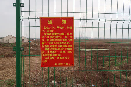 A government announcement of a land request is seen on a fence on the land secured by Tesla for its Gigafactory in Shanghai, China November 11, 2018. REUTERS/Yilei Sun