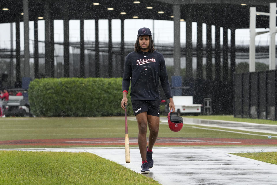 Washington Nationals' James Wood heads to the clubhouse in a steady rain after working in the batting cage during a spring training baseball workout Sunday, Feb. 18, 2024, in West Palm Beach, Fla. (AP Photo/Jeff Roberson)