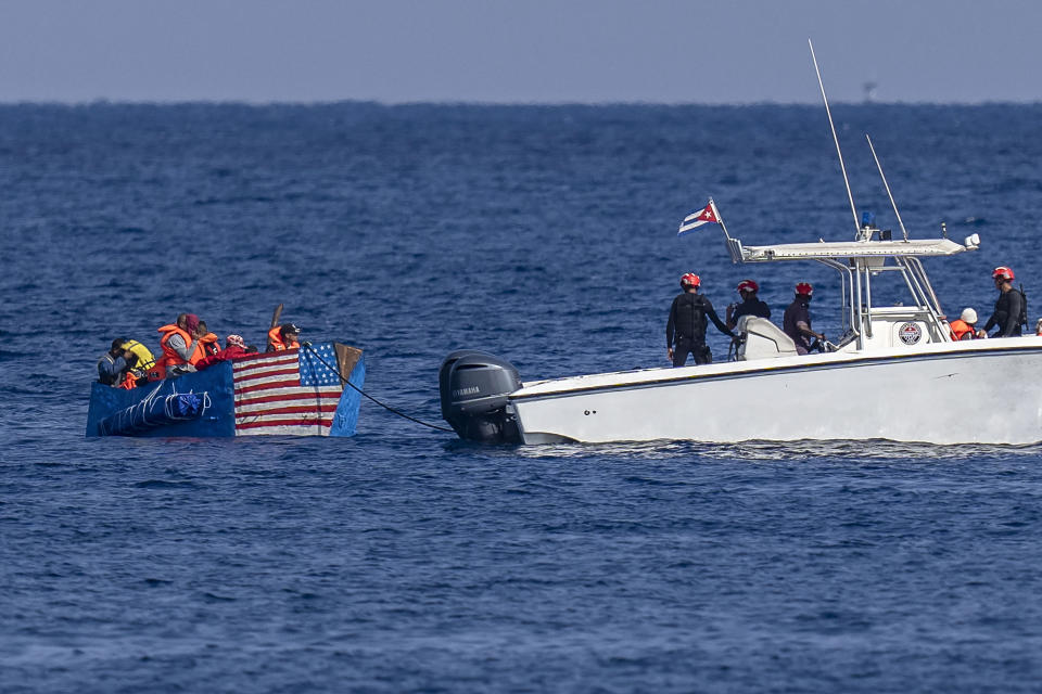 People in a makeshift boat with the U.S. flag painted on the side are captured by the Cuban Coast Guard, seen from the Malecon seawall in Havana, Cuba, Monday, Dec. 12, 2022. (AP Photo/Ramon Espinosa)