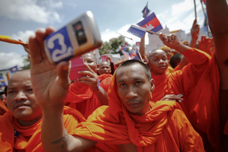 A Buddhist monk records the speech of one of the leaders of Cambodia National Rescue Party (CNRP) during a rally in Phnom Penh September 7, 2013. Thousands of supporters of Cambodia's defiant opposition rallied on Saturday to demand an independent probe into July elections they say were rigged to prolong the rule of a prime minister now facing his biggest political challenge in two decades. (REUTERS/Damir Sagolj)