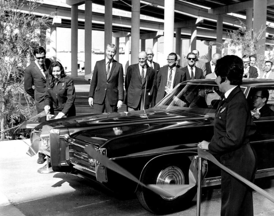 In 1970, parking officers hold a red ribbon as parking chairman Col. Mitchell Wolfson and Mayor Steve Clark break it with a blades to open a new parking lot under I-95 at West Flagler Street. Bob East/Miami Herald File