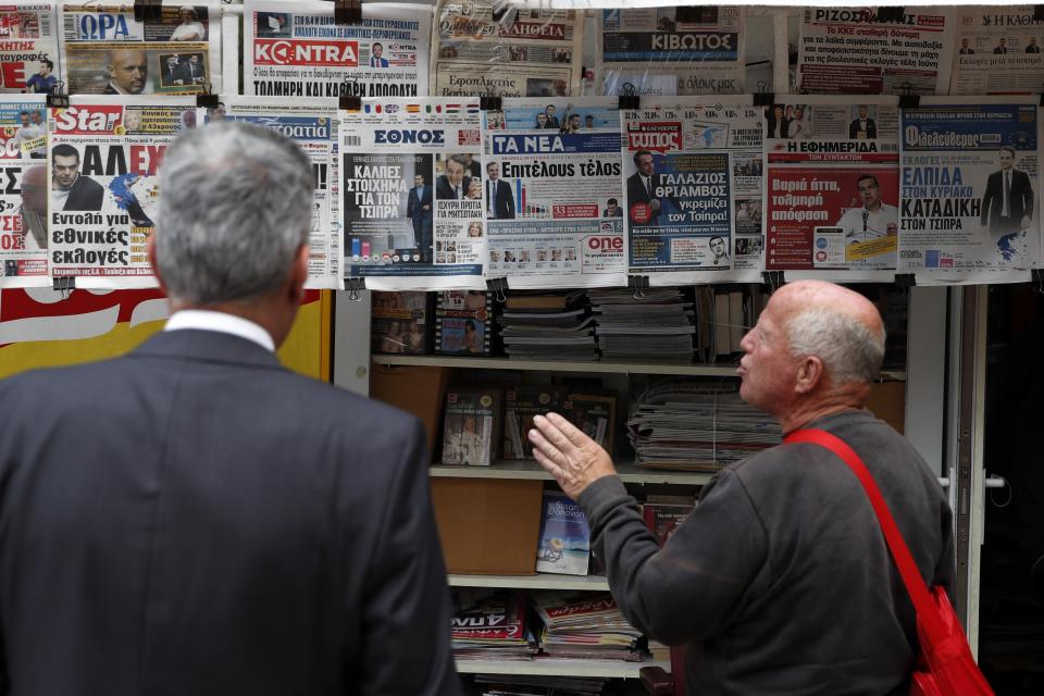 A man reacts as he reads the front pages of Greek newspapers in Athens, Monday, May 27, 2019. Greece's Prime Minister Alexis Tsipras called snap general elections following a resounding defeat of his left-wing Syriza party in European elections. (AP Photo/Thanassis Stavrakis)