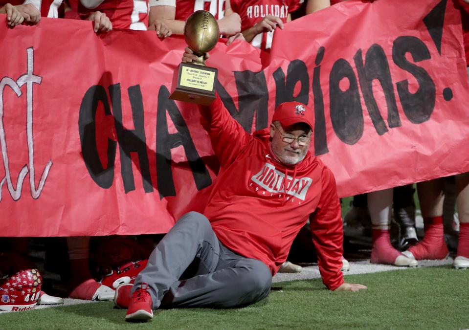 Holliday head football coach Frank Johnson holds up the golden football Friday, Nov. 13, 2020, after defeating Millsap in the Region II-3A Division II bi-district playoff in Graham.