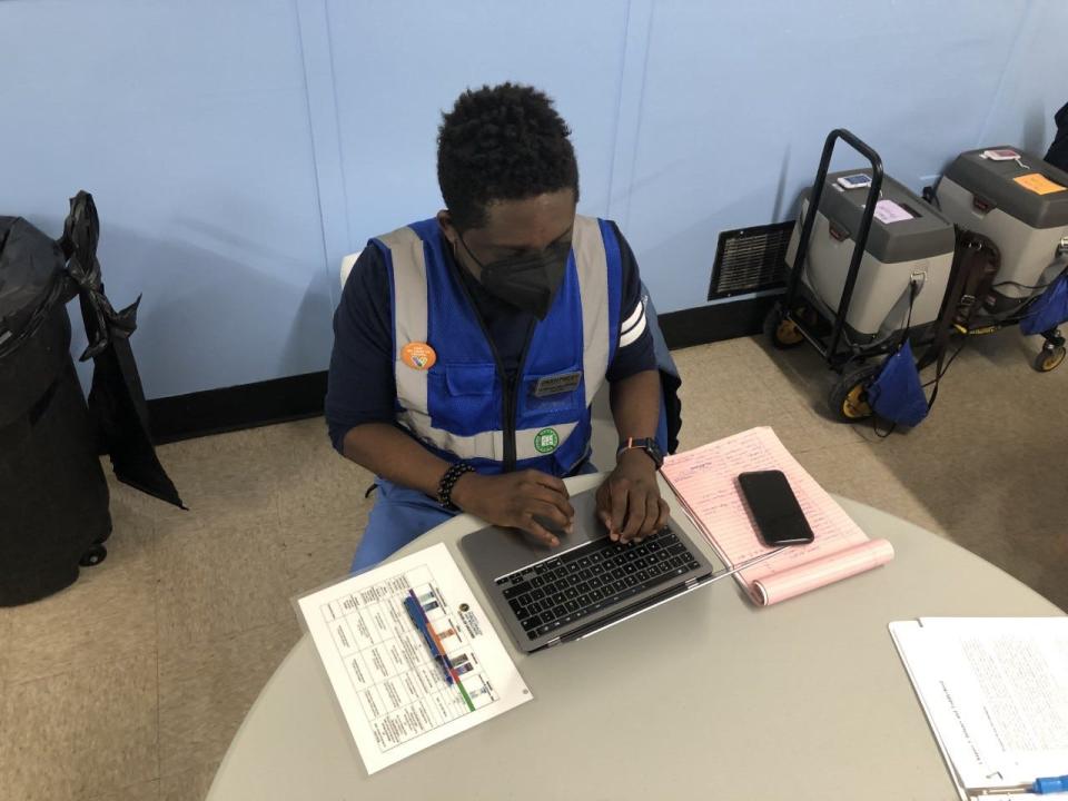 Oluwasegun Abe does paperwork on his laptop while waiting on patients at a LouVax clinic at Shawnee Community Center on Thursday,  Jan. 13, 2022.