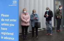 FILE - In this Monday, Jan. 11, 2021 file photo, people wait in line for the Oxford/AstraZeneca vaccine at the mass vaccination centre in Newcastle Upon Tyne, England. The British government says it aims to give every adult in the country a first dose of coronavirus vaccine by July 31, a month earlier than its previous target. In addition, the goal is for everyone over 50 or with an underlying health condition to get a shot by April 15, rather than the previous target of May 1. (AP Photo/Scott Heppell, File)