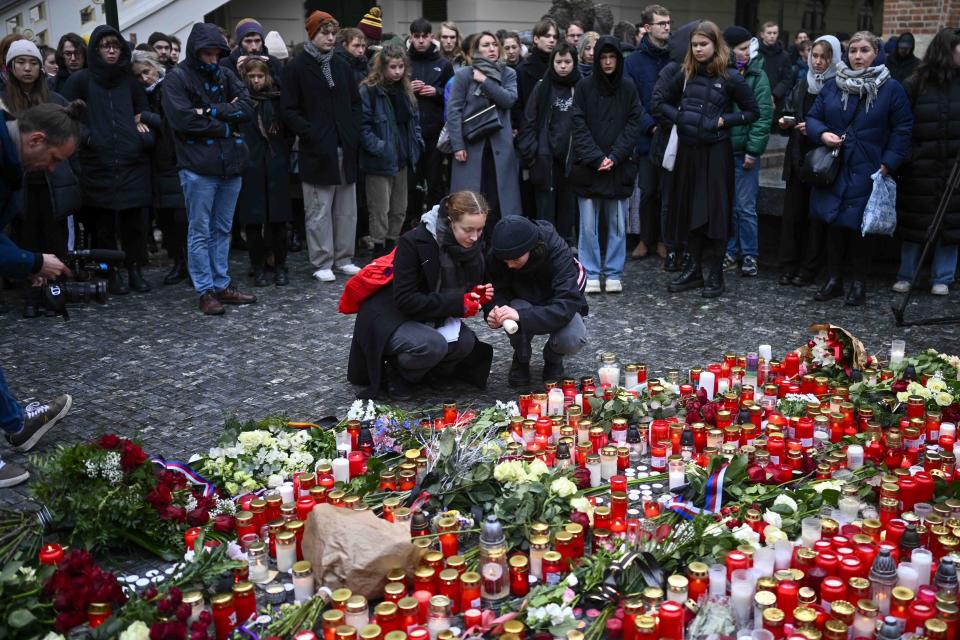 Mourners lay candle lights outside the headquarters of Charles University for victims of mass shooting in Prague, Czech Republic, Friday, Dec. 22, 2023. A lone gunman opened fire at a university on Thursday, killing more than a dozen people and injuring scores of people. (AP Photo/Denes Erdos)