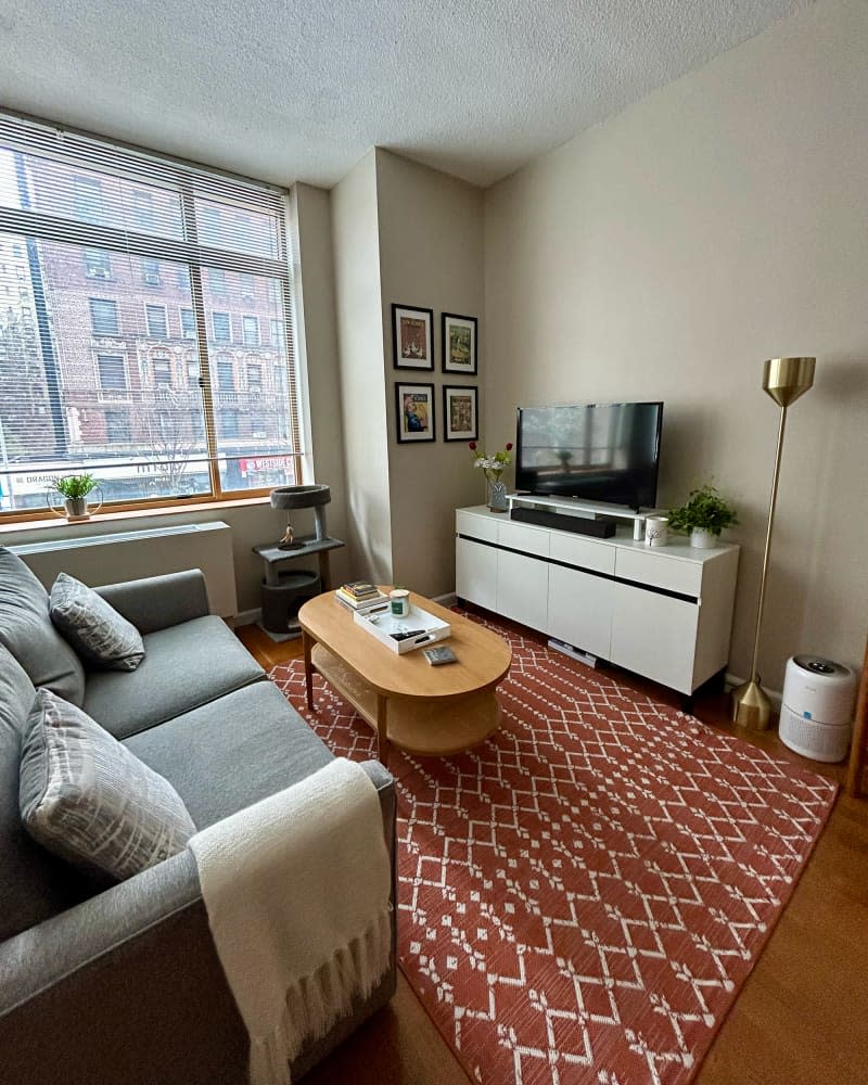 Brass lamp next to media console in studio apartment.