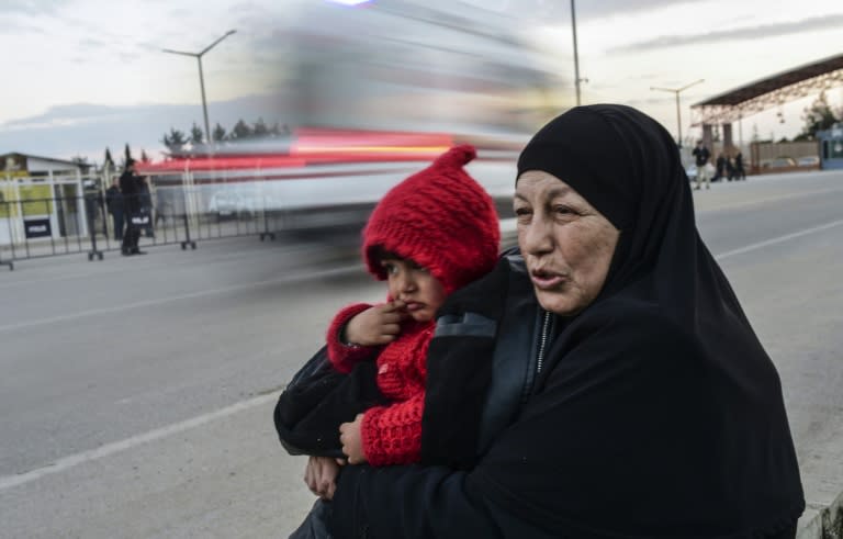 Syrian refugee Hatice Henidil hugs her grandson Usame while waiting for Usame's parents still stuck on the Syrian side of the border at the Oncupinar crossing gate, near the town of Kilis, in south-central Turkey, on February 10, 2016