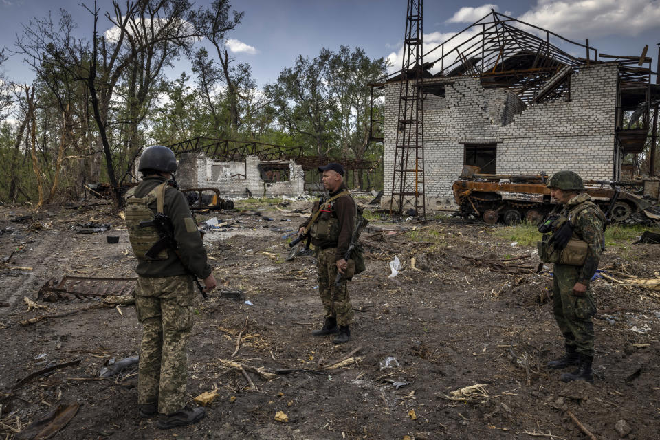 Un grupo de militares ucranianos pasa junto a vehículos blindados rusos destruidos en una zona boscosa a poca distancia del río Síverski Donets cerca de Severodonetsk, Ucrania, el miércoles 25 de mayo de 2022. (Ivor Prickett/The New York Times)
