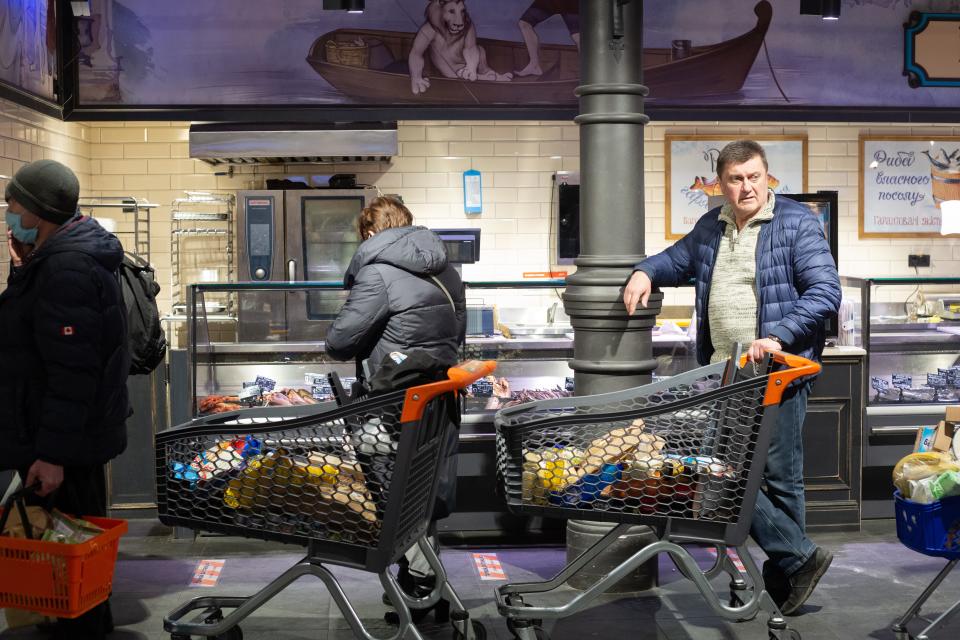 People wait in a line with groceries at the supermarket on Feb. 28, 2022 in Kyiv, Ukraine.