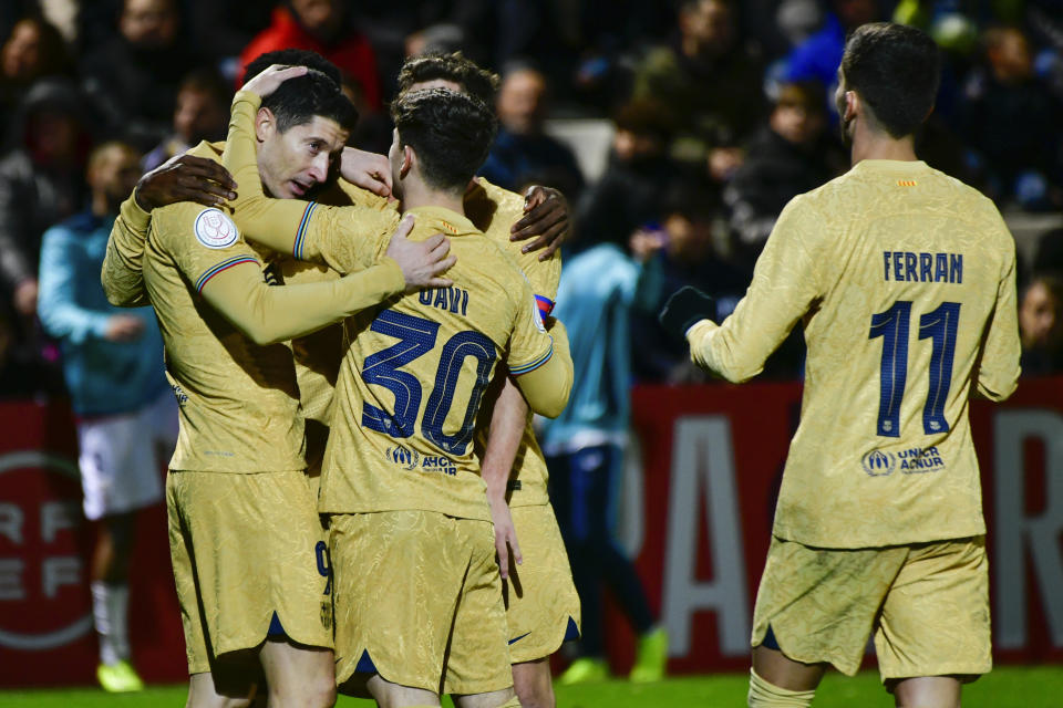 Robert Lewandowski (izquierda) celebra con sus compañeros tras anotar un gol para el Barcelona en el partido contra Ceuta en la Copa del Rey, el jueves 19 de enero de 2023. (AP Foto/Antonio Sempere)