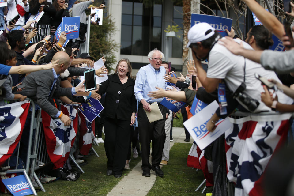 FILE - In this March 23, 2019, file photo, Democratic presidential candidate Sen. Bernie Sanders, I-Vt., center right, and his wife, Jane, arrive at a rally at Grand Park in Los Angeles. A persistent group of Sanders supporters say they won’t let go of the slights from the 2016 primary fight against Hillary Clinton. The frustration is notable now that Sanders is a 2020 front-runner, raking in $18.2 million in the first quarter, downplaying concerns about DNC bias and highlighting his success in bringing the party around on liberal policies it once resisted. (AP Photo/Damian Dovarganes, File)