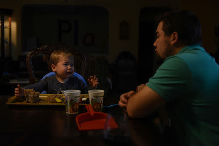 Will Hoffmann comforts his son Asa as they play with kinetic sand in San Antonio, Texas, U.S., February 22, 2019. REUTERS/Callaghan O'Hare