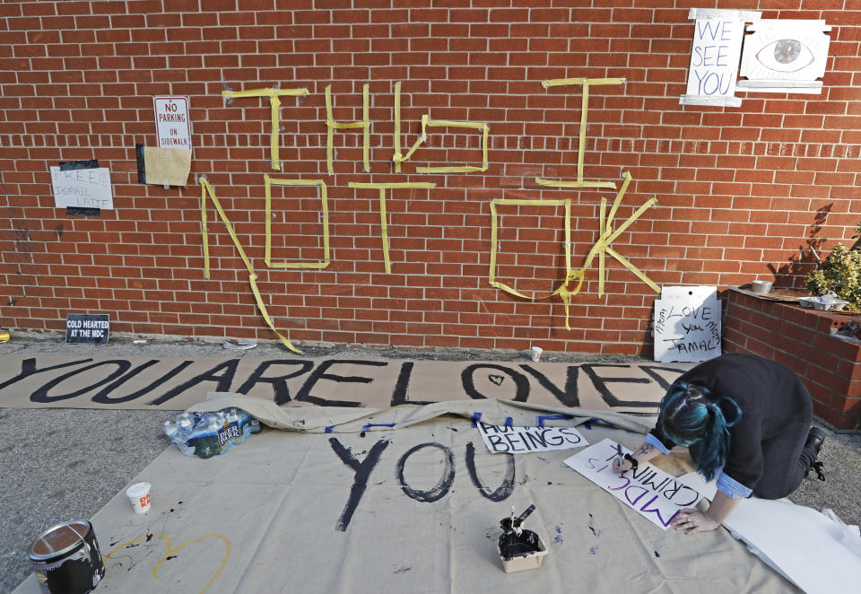 A woman makes a sign outside the Metropolitan Detention Center, a federal facility of all security levels, Sunday, Feb. 3, 2019, in the Brooklyn borough of New York. Prisoners there have been without heat, hot water, electricity and sanitation for a week. (AP Photo/Kathy Willens)