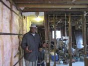 Houston resident Lawrence Hester stands with his grandson Friday, January 31, 2020, as he discussed the repairs taking place at his home to fix damage from Hurricane Harvey in 2017. Hester said he was unable to get help from a city program created to fix homes damaged during Harvey and had to endure hazardous living conditions for more than two years. He turned to a local nonprofit to fix his home. The city program has finished rebuilding less than 70 homes since beginning in January 2019. (AP Photo/Juan Lozano)