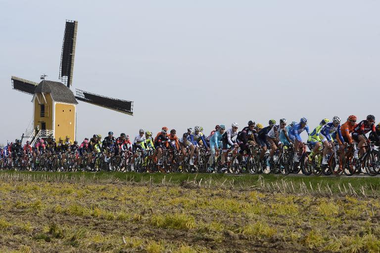 The pack of riders cycles past a windmill during the 50th edition of the 258km Amstel Gold race from Maastricht to Berg en Terblijt, Netherlands on April 19, 2015