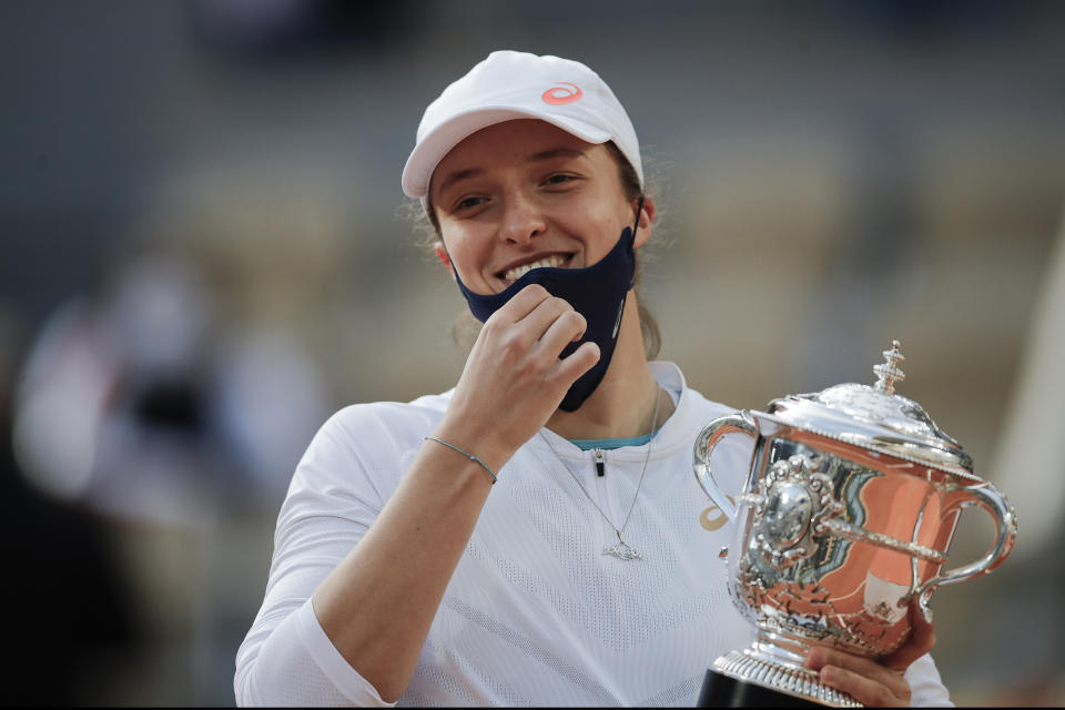 FILE - In this Saturday, Oct. 10, 2020 file photo, Poland's Iga Swiatek holds the trophy after winning the final match of the French Open tennis tournament against Sofia Kenin of the U.S. in two sets 6-4, 6-1, at the Roland Garros stadium in Paris, France. French Open champion Iga Swiatek said she will quarantine after meeting with Poland President Andrzej Duda. Duda's office announced Saturday, Oct. 24, 2020 that he tested positive for coronavirus. The 19-year-old Swiatek met with Duda on Friday. (AP Photo/Christophe Ena, File)