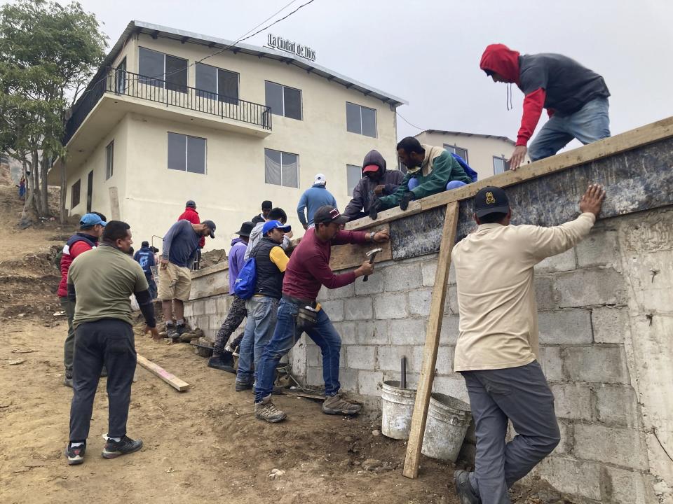 Migrant volunteers build a soccer field at Templo Embajadores de Jesus, Tijuana's largest migrant shelter, Thursday, Oct. 13, 2022, in Tijuana, Mexico. The Biden administration's policy shift on Venezuelan migrants may pose an enormous challenge to overstretched Mexican shelters. The U.S. has coupled plans to let up to 24,000 Venezuelans apply online to fly to the U.S. for temporary stays with a pledge to immediately turn back Venezuelans who cross the border illegally from Mexico.(AP Photo/Elliot Spagat)