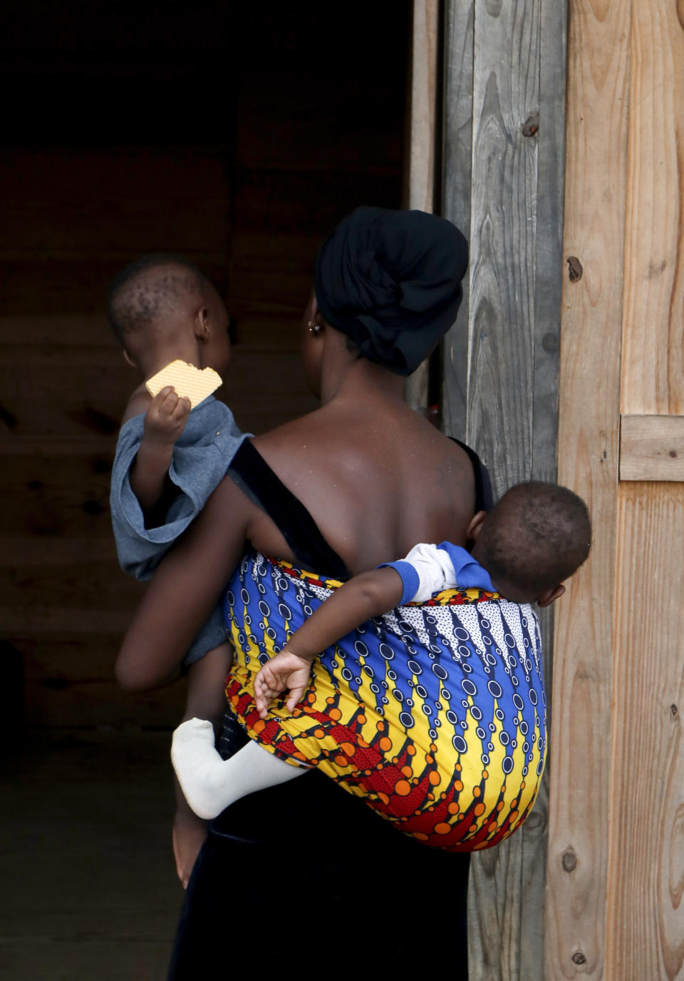 A migrant woman carrying two children arrives at a shelter in Lajas Blancas, Darien, Panama, Saturday, Oct. 23, 2021. A rising number of female migrants have reported suffering sexual abuse while crossing the treacherous Darien Gap between Colombia and Panama. Seeking to draw attention to the issue, a group of Panamanian lawmakers travelled Saturday on a fact-finding mission to speak with victims and authorities in the remote province. (AP Photo/Ana Renteria)