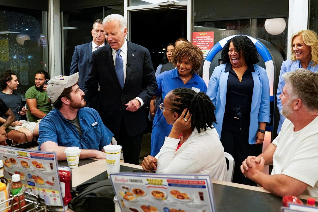 President Joe Biden greets people as he and First Lady Jill Biden pick up an order from a Waffle House in Marietta, Georgia (REUTERS)