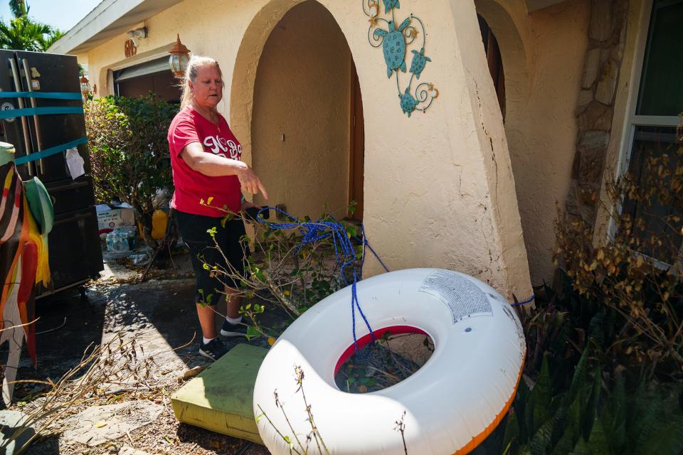 Oct 5, 2022; Fort Myers, FL, USA; Peggy Zachritz points to an inner tube that she and her husband Bruce tied to their front porch to stay above floodwaters that took over their home and neighborhood shortly after Hurricane Ian hit the Fort Myers area. Zachritz said she and her husband felt more safe floating in the floodwater on their porch than inside their home. They eventually took shelter at a neighbor's home whose second floor was above the water level.. Mandatory Credit: Josh Morgan-USA TODAY